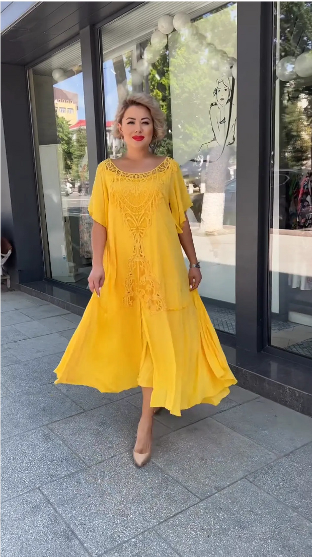 Frau in einem gelben Spitzenkleid geht selbstbewusst