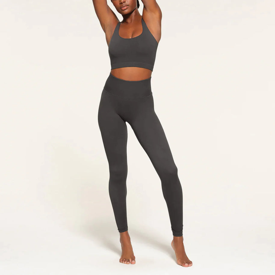 Stilvolle Frau von vorne in nahtlosen Leggings, die ihre glatte Passform und ihr schmeichelhaftes Design betonen