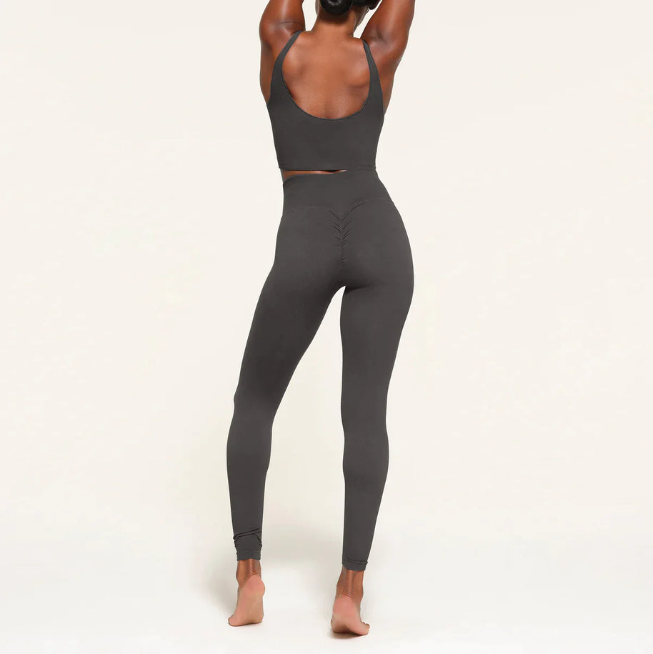 Stilvolle Frau von hinten in nahtlosen Leggings aufgenommen, wobei die glatte Passform und das schmeichelhafte Design hervorgehoben werden
