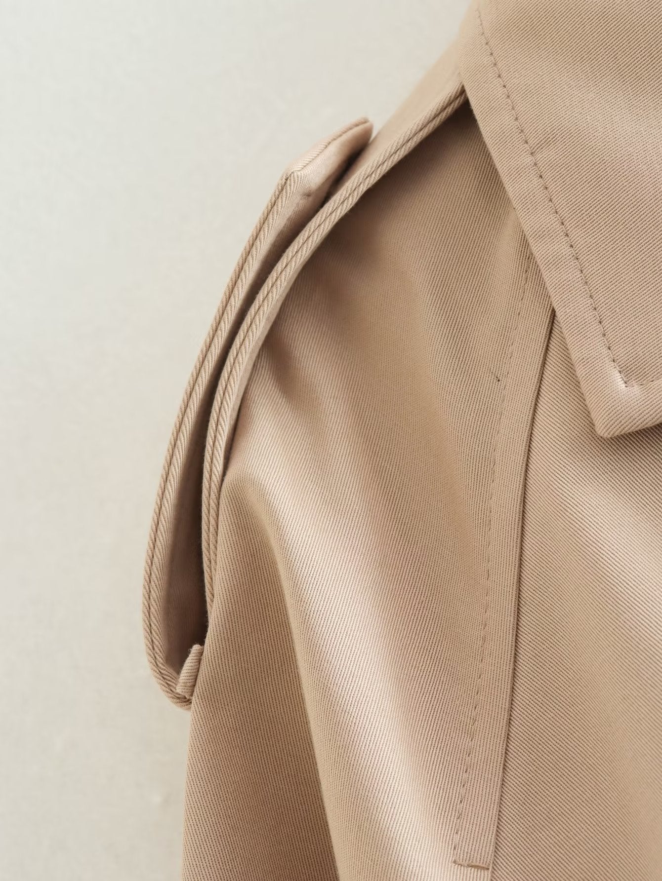 Nahaufnahme einer kurzen Jacke, die den Stoff und das Schulterdesign hervorhebt