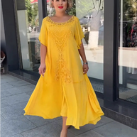 Frau in einem gelben Spitzenkleid geht selbstbewusst