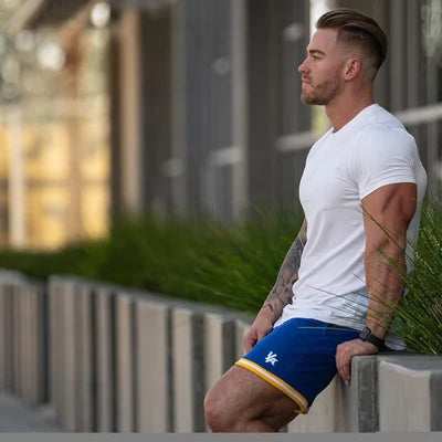 Ein Mann trägt ein weißes Essential T-Shirt mit tiefem Schnitt