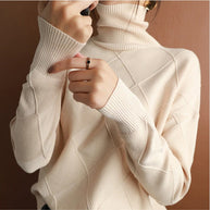 Eine Frau trägt einen beige Rollkragenpullover