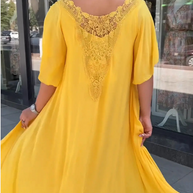Rückansicht einer kurzhaarigen Frau im gelben Kleid