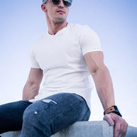 Ein Mann trägt ein weißes Essential T-Shirt mit tiefem Schnitt