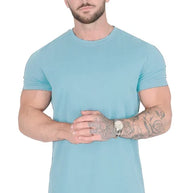 Ein Mann trägt ein himmelblaues Drop-Cut-T-Shirt