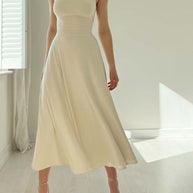 Frau im beigen Kleid mit breiten Trägern