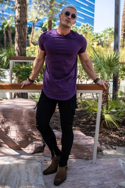Ein Mann trägt ein lila Essential T-Shirt mit tiefem Schnitt