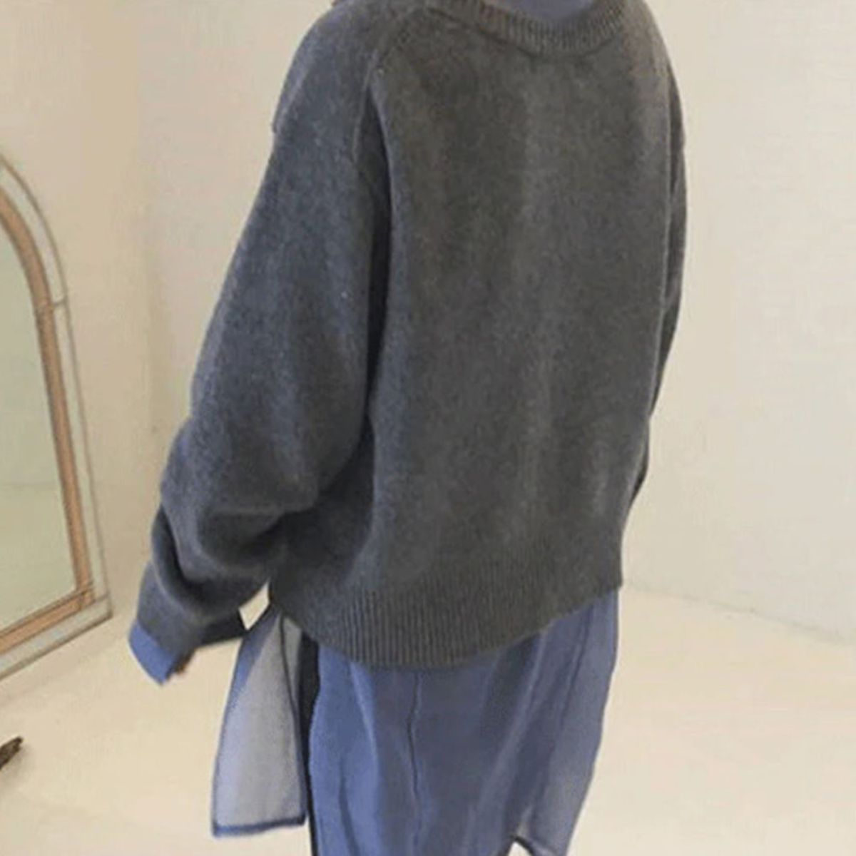 Rückansicht einer Frau die einen stylischen Pullover trägt