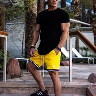 Ein Mann trägt ein schwarzes Drop-Cut T-Shirt