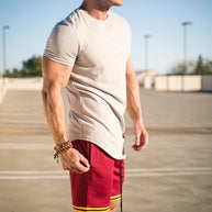 Ein Mann trägt ein weißes Essential T-Shirt mit tiefem Schnitt