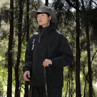 Ein Mann trägt eine wind- und wasserdichte Outdoor-Kapuzenjacke mit langen Ärmeln und farblich abgestimmtem Reißverschluss