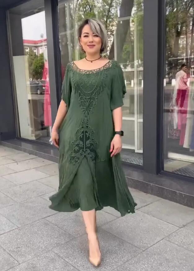 Stilvolle Frau im grünen Kleid mit kurzen Haaren und Absätzen