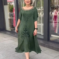 Stilvolle Frau im grünen Kleid mit kurzen Haaren und Absätzen