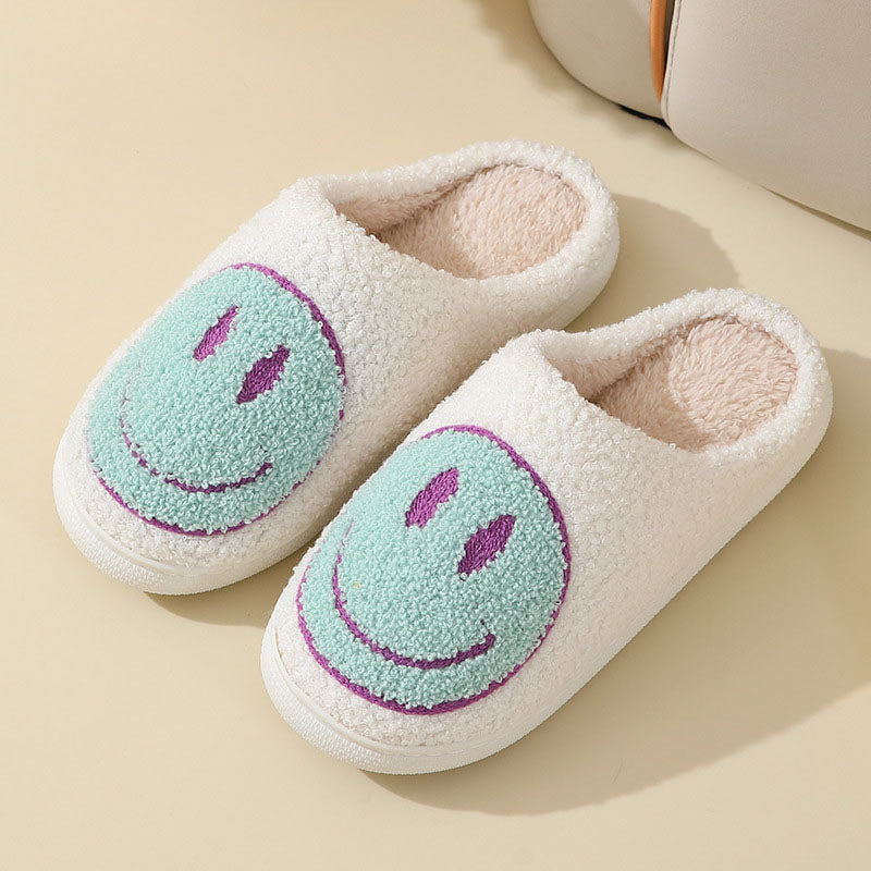 Ein Paar Pelzpantoffeln mit himmelblauem Smiley-Design