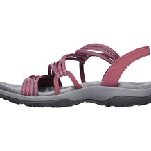Rosafarbene orthopädische Sandalen mit überkreuzten Riemen auf weißem Hintergrund