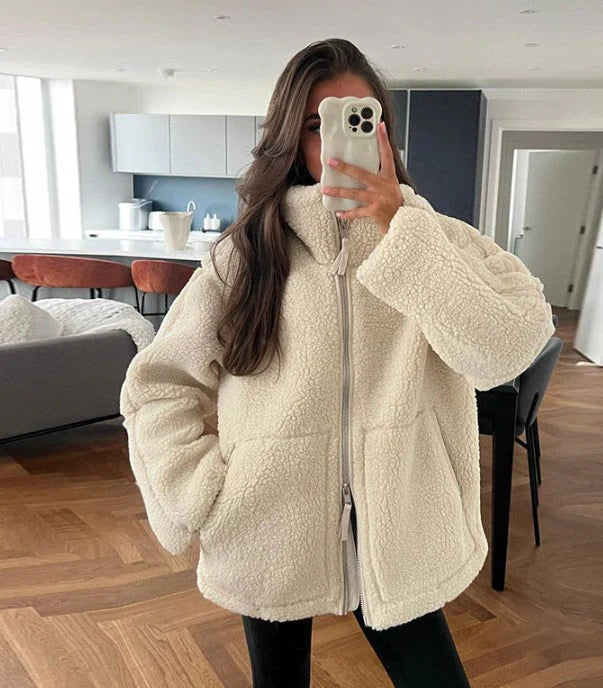 Spiegelaufnahme einer frau, die eine beige lammwolljacke trägt