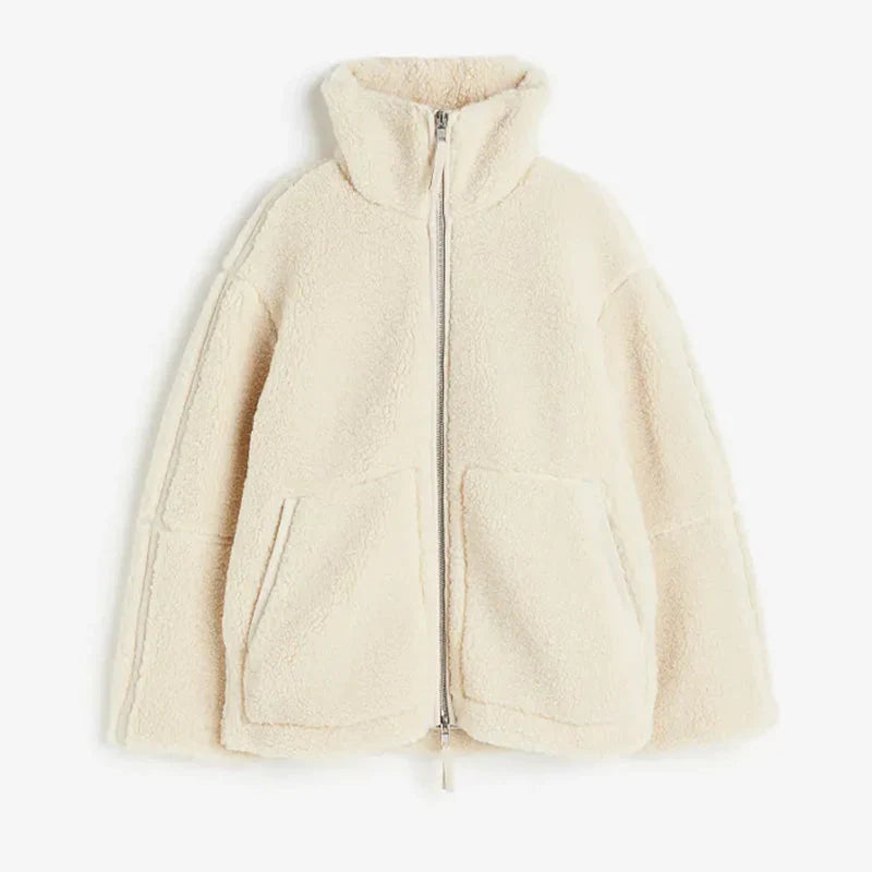 Beige lammwolljacke auf weißem hintergrund