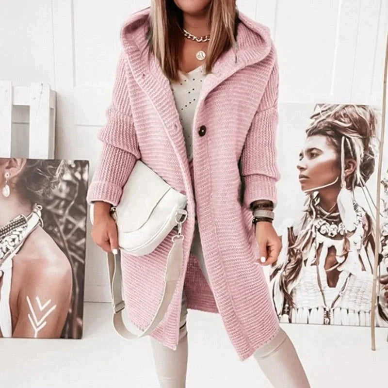 Lange, rosa Strickjacke mit Kapuze und zwei schwarzen Knöpfen
