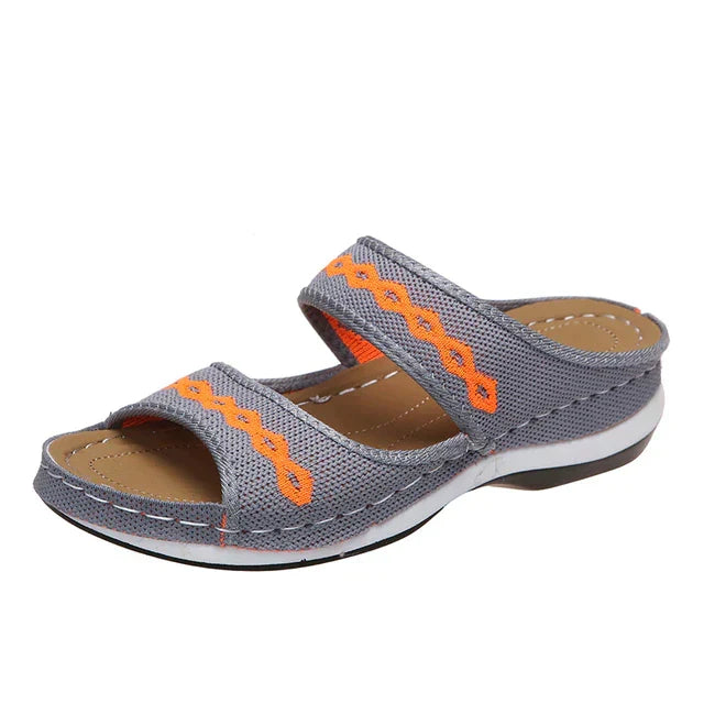 Ein einzelner grau orthopädischer sommerschuh auf einem weißen hintergrund