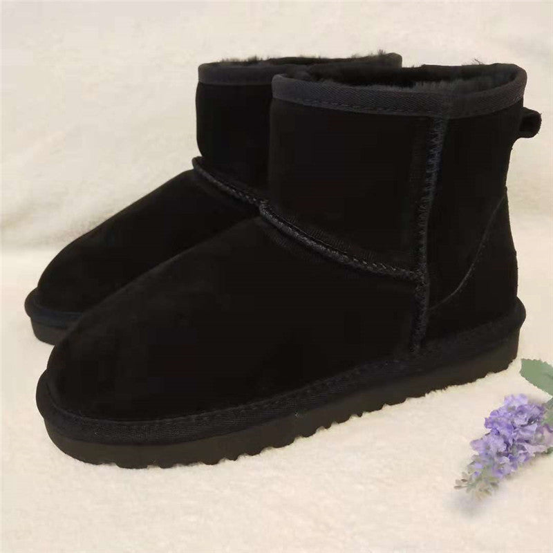 Schwarz echtleder schneestiefel mit kunstfell neben einer kleinen lavendelblume