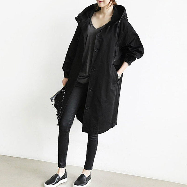 Ein Modell, das einen langer schwarz trenchcoat trägt