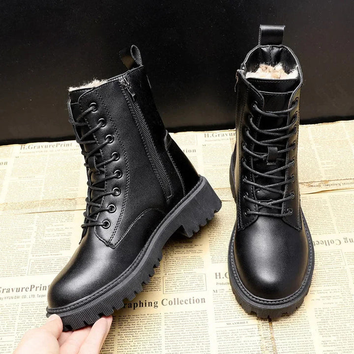 Schwarze leder winterstiefel auf einem zeitungs-hintergrund