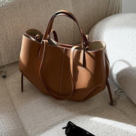 Braun ledertasche auf einem sofa