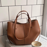 Braun ledertasche neben einer leeren kaffeetasse auf einem tisch