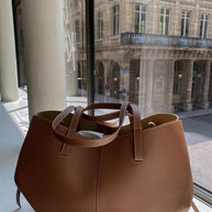 Braun ledertasche auf einem fensterbrett, mit blick auf ein klassisches gebäude draußen