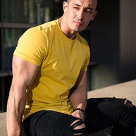 Ein Mann trägt ein gelbes Essential T-Shirt mit tiefem Schnitt