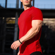 Ein Mann trägt Rot Essential T-Shirt mit tiefem Schnitt