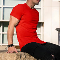 Ein Mann trägt ein rotes Essential T-Shirt mit tiefem Schnitt