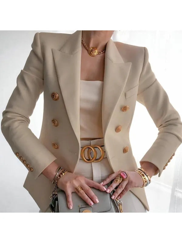 Eine Frau trägt einen beigen Blazer aus altem Geld mit goldenem Knopfdesign
