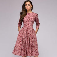 Frau die ein rosa retrozo edles mittel-langes Kleid trägt