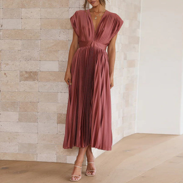 Model in einem rosenrot kleid mit v-ausschnitt, stehend in einem hellen, modernen innenraum
