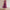 Model in einem paars kleid mit v-ausschnitt, stehend in einem hellen, modernen innenraum