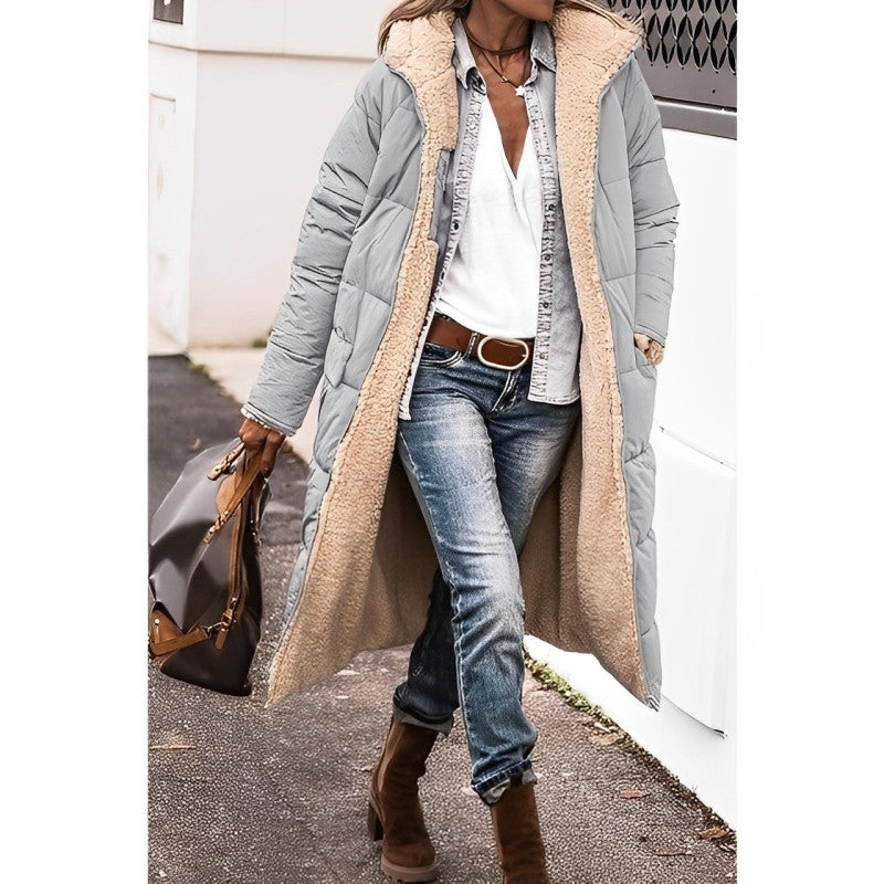 Eine frau in einem langer, bequemer grau mantel und jeans