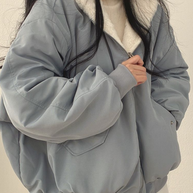 Nahaufnahme einer blauen Wendejacke mit Kapuze, Reißverschluss und Tasche