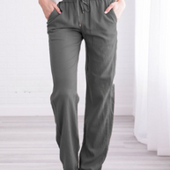 Eine Frau trägt dunkelgraue Sommerhosen auf weißem Hintergrund