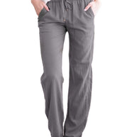 Eine Frau in grauer Sommerhose auf weißem Hintergrund